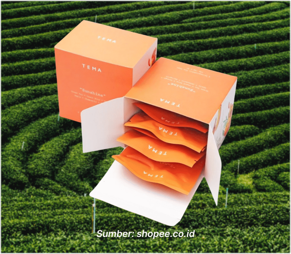Box teh berwarna oranye "Sunshine - Peach Green Tea" dari TEMA